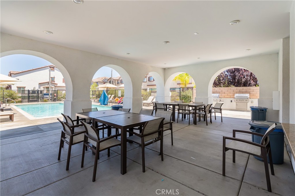 41973 Rondo Street, Unit 1203 Murrieta, CA 92562 - Photo 40 of 48 a view of a dining room with furniture a chandelier and wooden floor