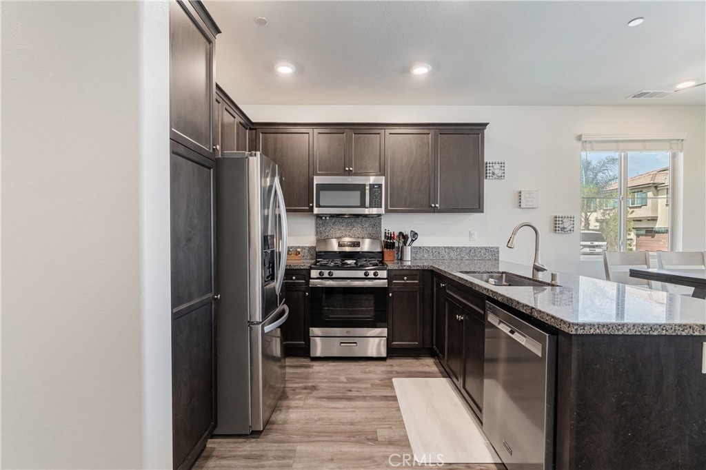 41973 Rondo Street, Unit 1203 Murrieta, CA 92562 - Photo 6 of 48 a kitchen with stainless steel appliances granite countertop a sink stove and refrigerator