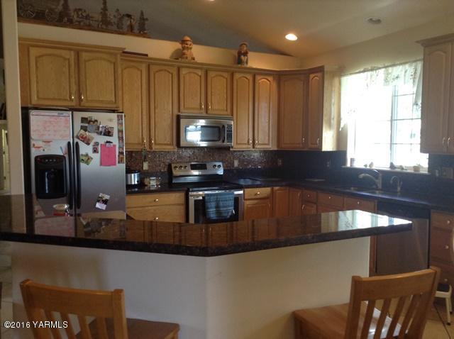 5407 Postma Road Yakima, WA 98901 - Photo 22 of 31 a kitchen with stainless steel appliances granite countertop a stove a sink and a microwave