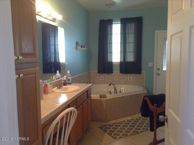 5407 Postma Road Yakima, WA 98901 - Photo 30 of 31 a bathroom with a double vanity sink a mirror and bathtub