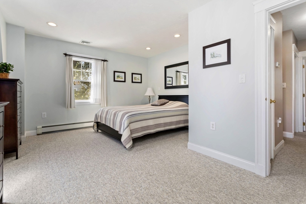 80 Squanto Road Quincy, MA 02169 - Photo 17 of 42 a spacious bedroom with a bed and a painting