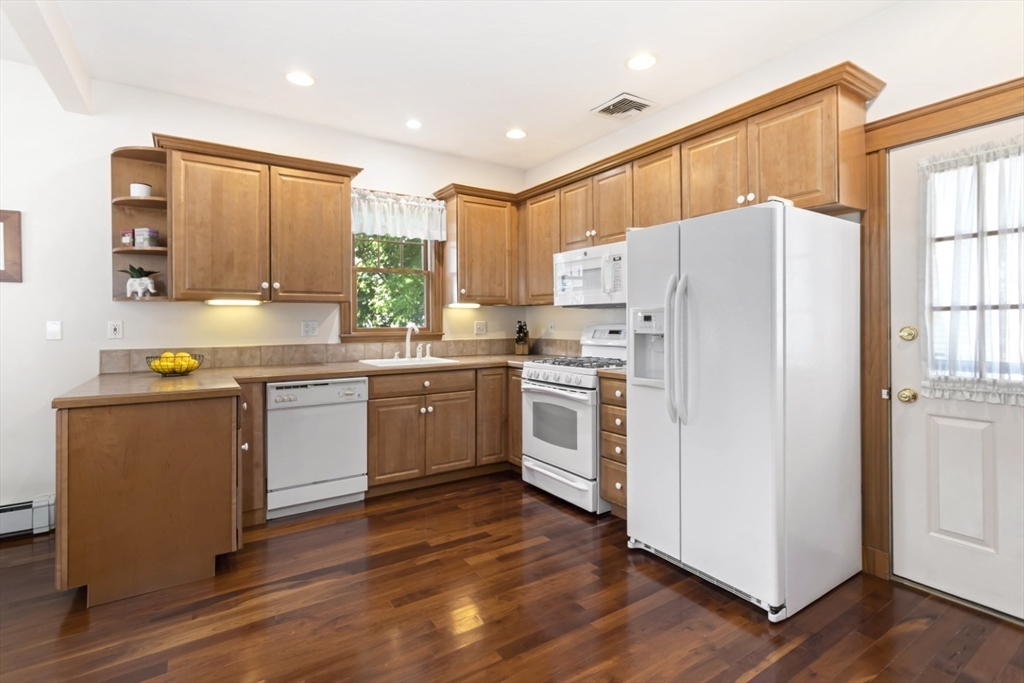 80 Squanto Road Quincy, MA 02169 - Photo 9 of 42 a kitchen with white cabinets and white appliances