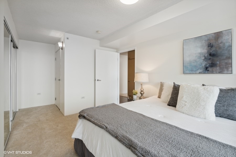 800 Elgin Road, Unit 1304 Evanston, IL 60201 - Photo 13 of 18 a bedroom with a bed and painting on the wall