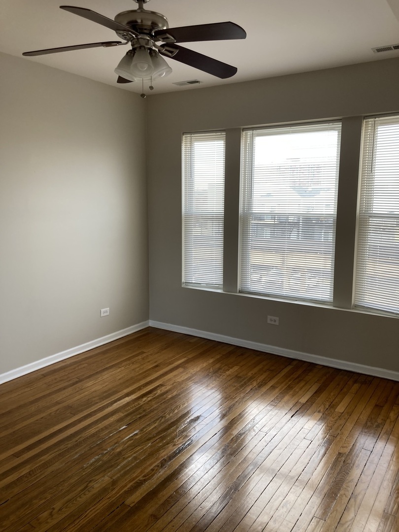 4042 South Calumet Avenue, Unit 3S Chicago, IL 60653 - Photo 2 of 11 a view of an empty room with wooden floor and a window