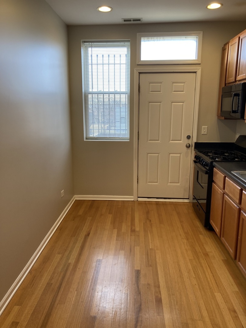 4042 South Calumet Avenue, Unit 3S Chicago, IL 60653 - Photo 4 of 11 wooden floor in an empty room with a window