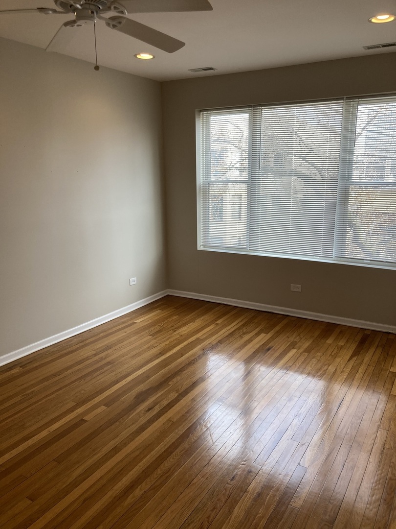 4042 South Calumet Avenue, Unit 3S Chicago, IL 60653 - Photo 8 of 11 wooden floor in an empty room with a window