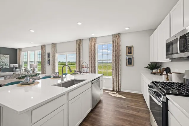 a kitchen with sink stove and refrigerator