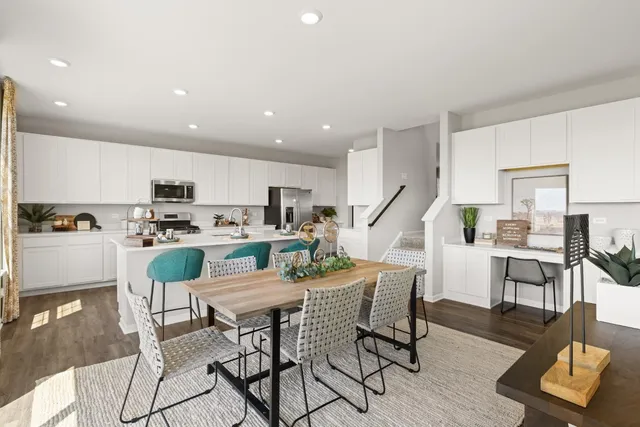 a kitchen with a dining table chairs and view of living room