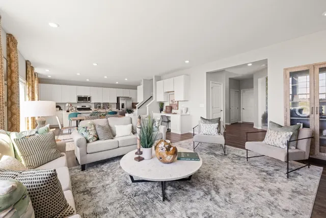a living room with furniture and a dining table with kitchen view