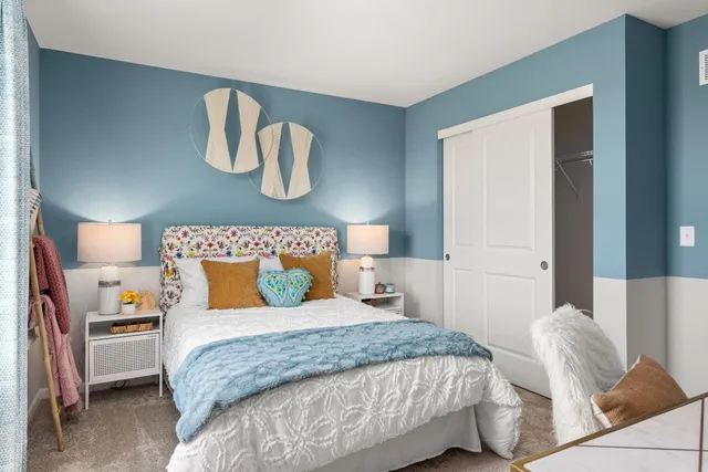 a bedroom with a bed and painting on the wall