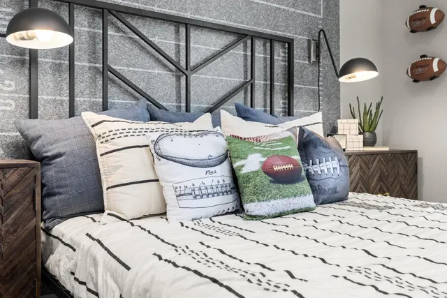 a bedroom with a bed a chandelier and a mirror