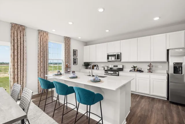 a kitchen with stainless steel appliances kitchen island granite countertop a stove a sink and a refrigerator