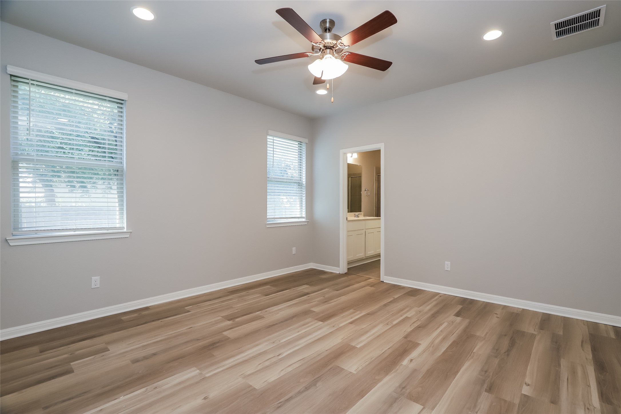 2724 Juniper Woods Road Leander, TX 78641 - Photo 9 of 21 Newly installed wood flooring grounds this naturally illuminated bedroom with direct bathroom access.