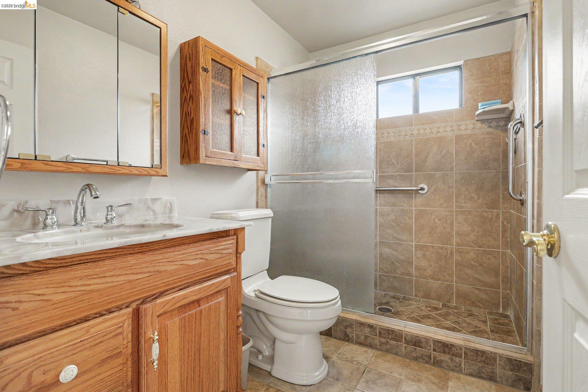 249 Madison Avenue Bay Point, CA 94565 - Photo 6 of 18 Bathroom featuring a wood-finish vanity with an integrated sink and a neutral stone-look countertop