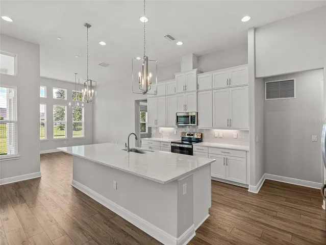 a kitchen with granite countertop a sink stove and refrigerator