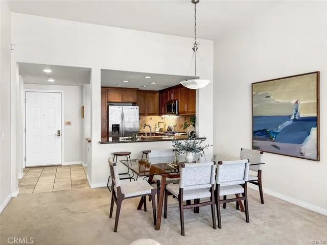 a kitchen with kitchen island a dining table and chairs