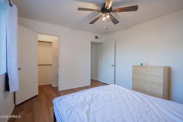 a bedroom with a bed and wooden floor