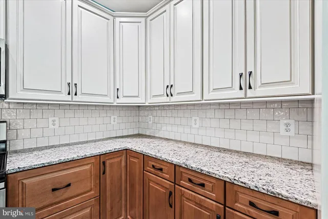 a kitchen with granite countertop white cabinets and sink
