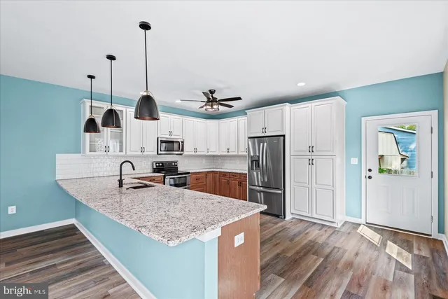 a kitchen with stainless steel appliances granite countertop a sink a refrigerator and a stove