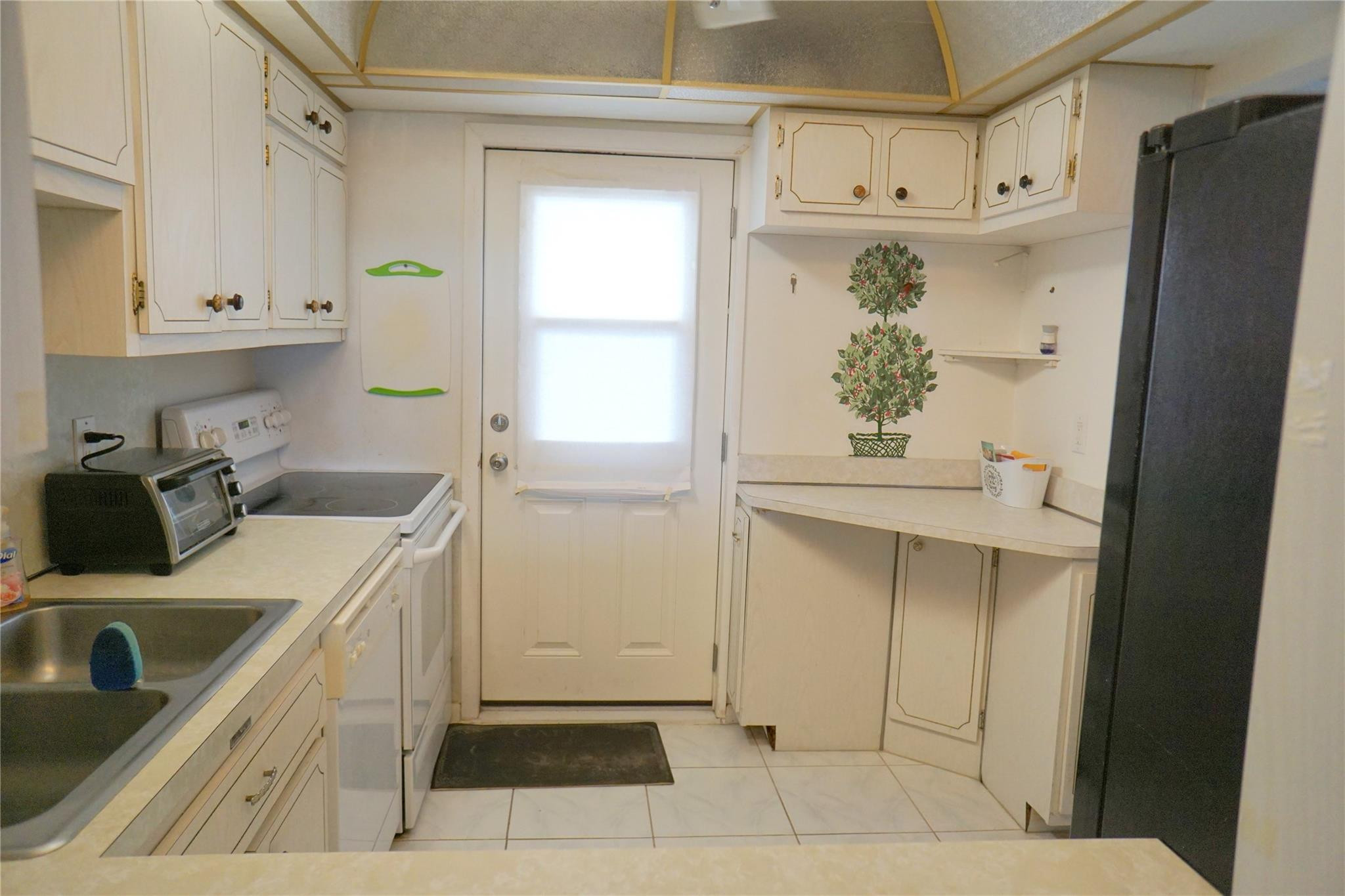 303 North Riverside Drive, Unit PH4 Pompano Beach, FL 33062 - Photo 12 of 52 a kitchen with white cabinets and refrigerator
