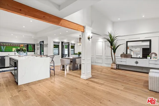 a living room with furniture and a large mirror with potted plants
