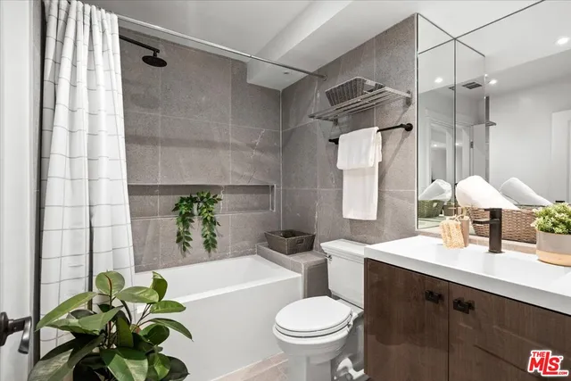 a bathroom with a granite countertop sink a toilet and shower