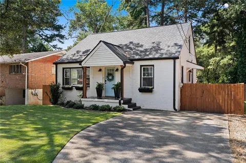 a view of a white house with a big yard and large tree
