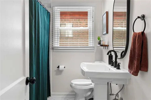 a bathroom with a sink a toilet and a mirror