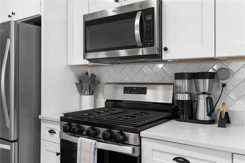 a kitchen with stainless steel appliances granite countertop a stove and a microwave