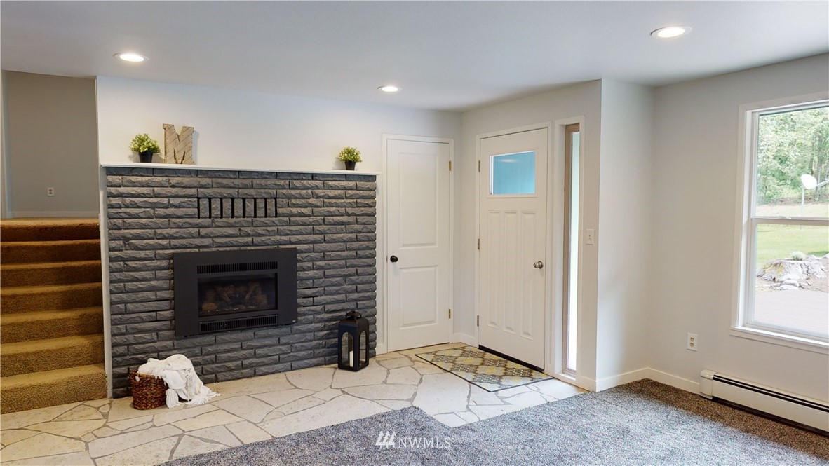 4086 Linnell Road Deming, WA 98244 - Photo 11 of 38 a living room with a fireplace and a window