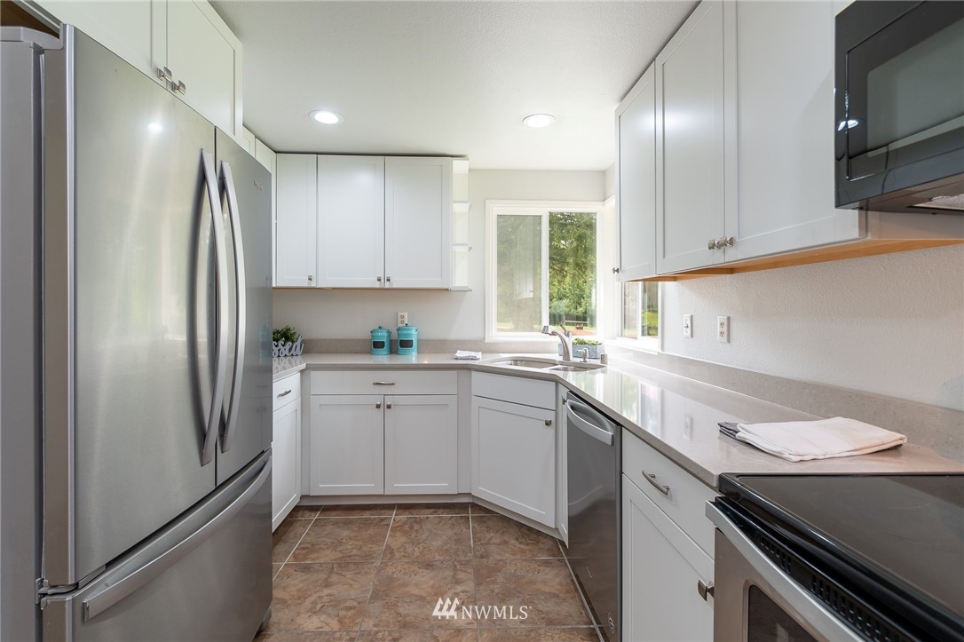 4086 Linnell Road Deming, WA 98244 - Photo 7 of 38 a kitchen with a sink stainless steel appliances and white cabinets