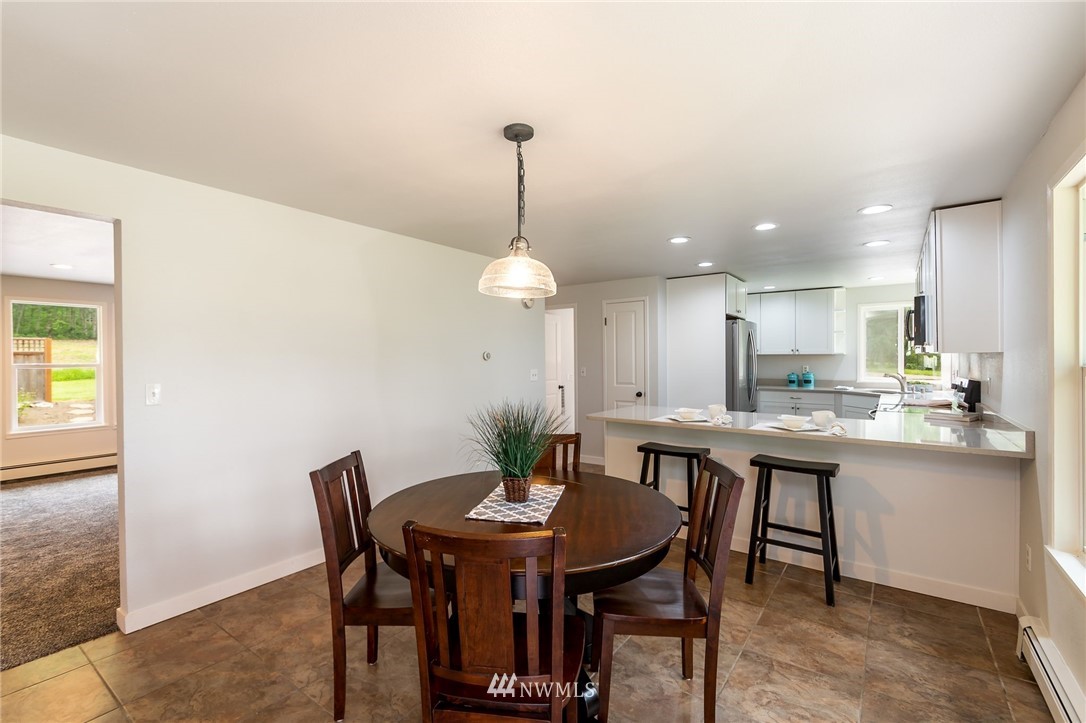 4086 Linnell Road Deming, WA 98244 - Photo 9 of 38 a dining room with a table chairs and a kitchen view