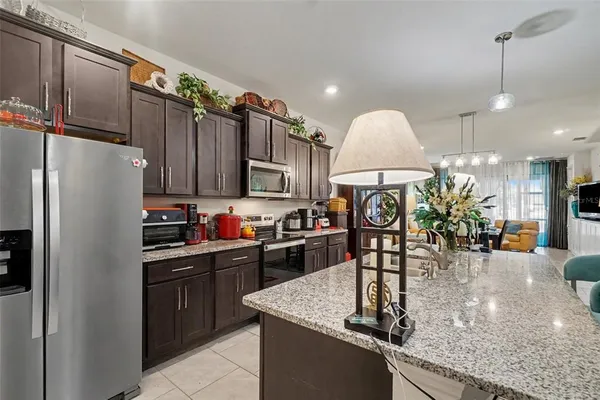 a kitchen with stainless steel appliances granite countertop a sink a stove and a refrigerator