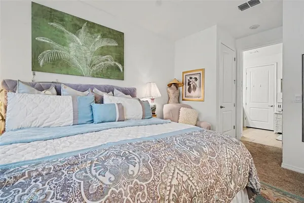a bedroom with a large bed and a painting on the wall
