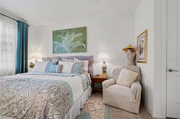 a bedroom with bed and a painting on the wall