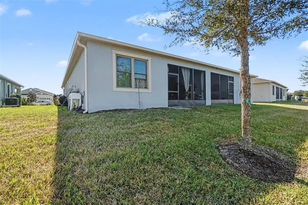 a view of a house with backyard and a tree