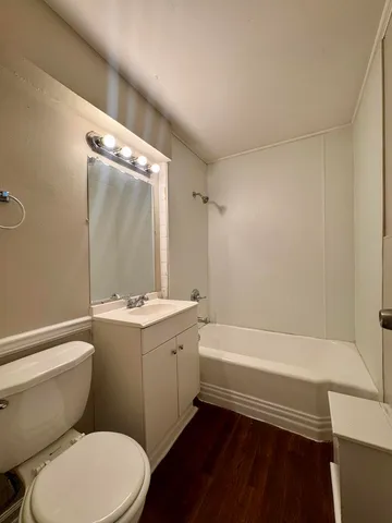 a bathroom with a sink a toilet a mirror and bathtub