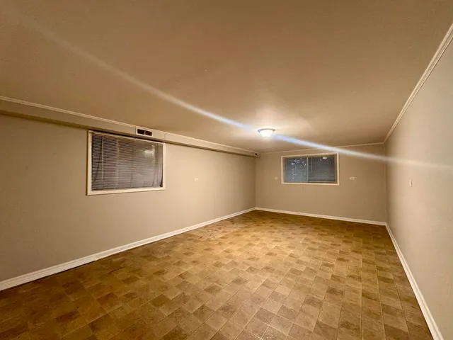 a view of a big room with wooden floor and windows