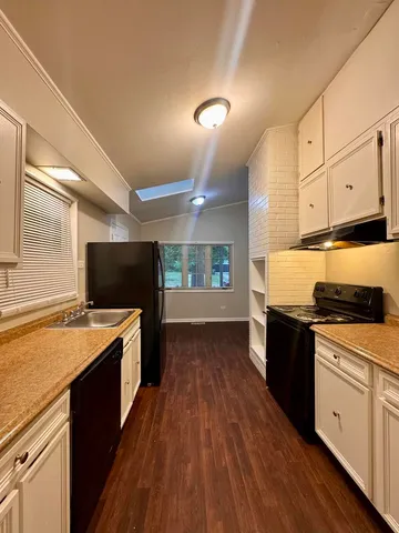 a kitchen with a sink stove top oven and cabinets