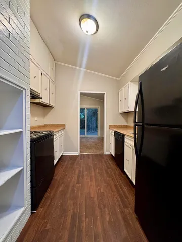 a kitchen with a refrigerator stove and wooden floor