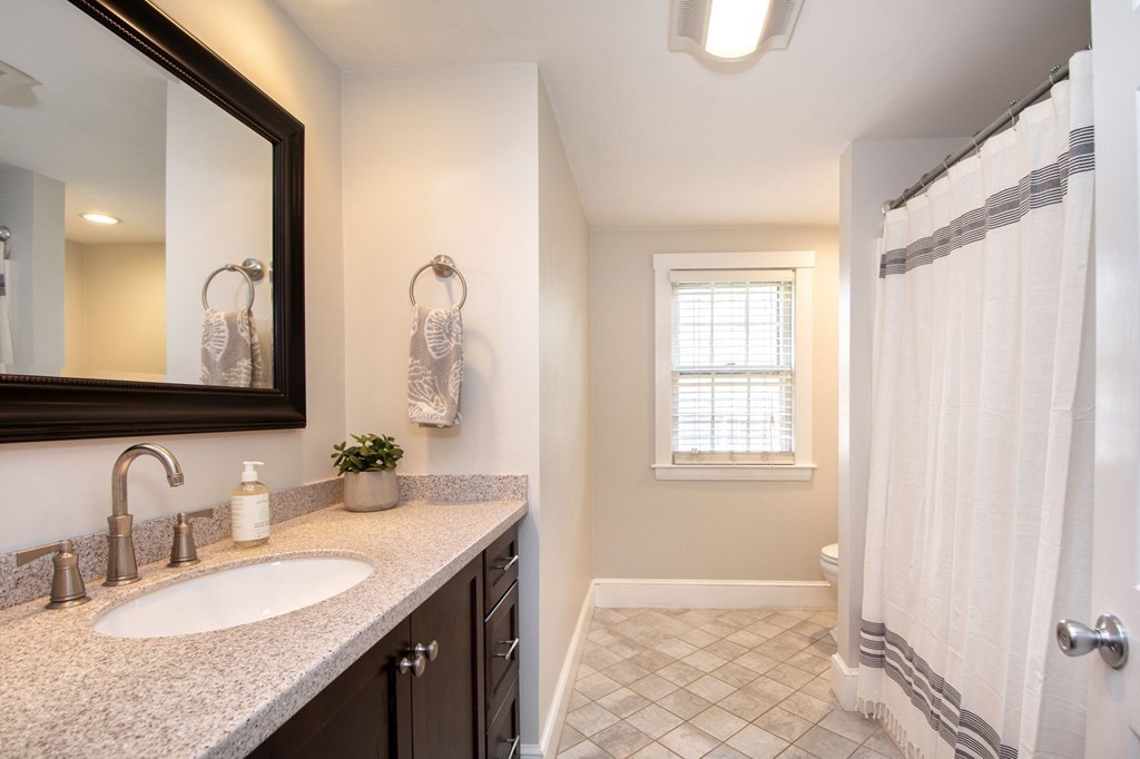 250 First Parish Road Scituate, MA 02066 - Photo 16 of 25 a bathroom with a granite countertop sink and a mirror