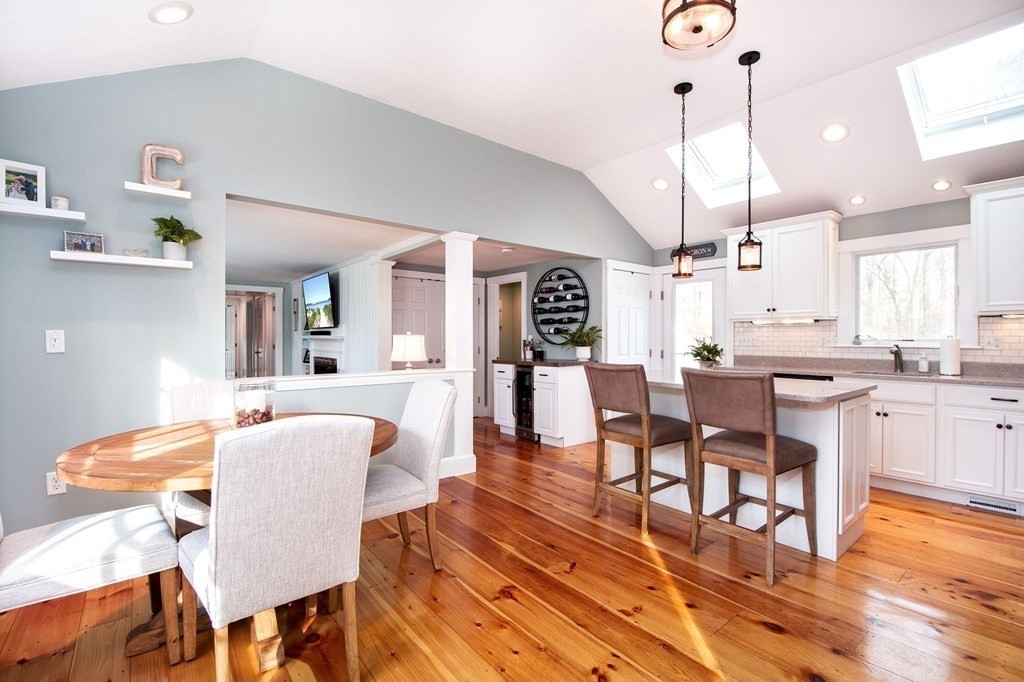 250 First Parish Road Scituate, MA 02066 - Photo 5 of 25 a dining room with wooden floor a chandelier a wooden table and chairs