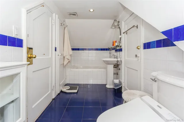 a bathroom with a tub shower sink and toilet