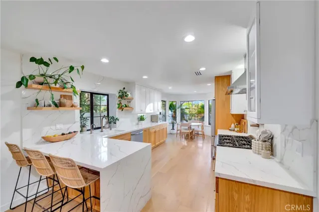 a dining room with furniture a livingroom view and wooden floor