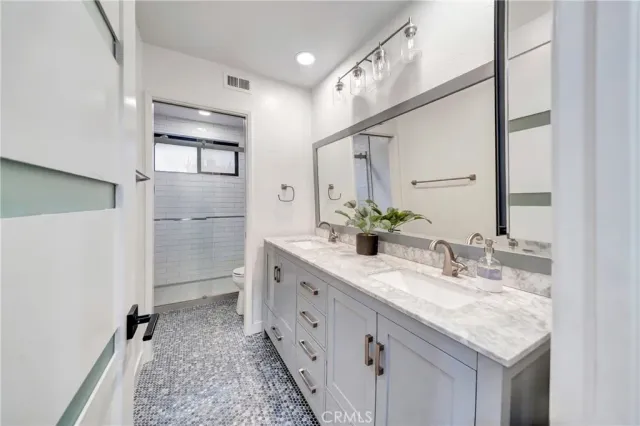 a bathroom with a granite countertop toilet and a shower