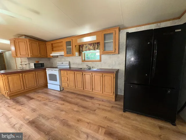 a kitchen with granite countertop a refrigerator and a stove top oven