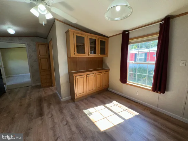 a view of an empty room with a chandelier fan