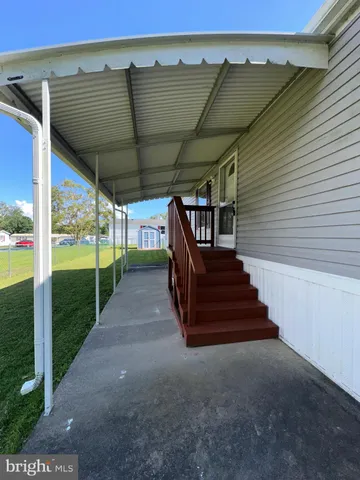 a backyard of a house with wooden fence and large trees