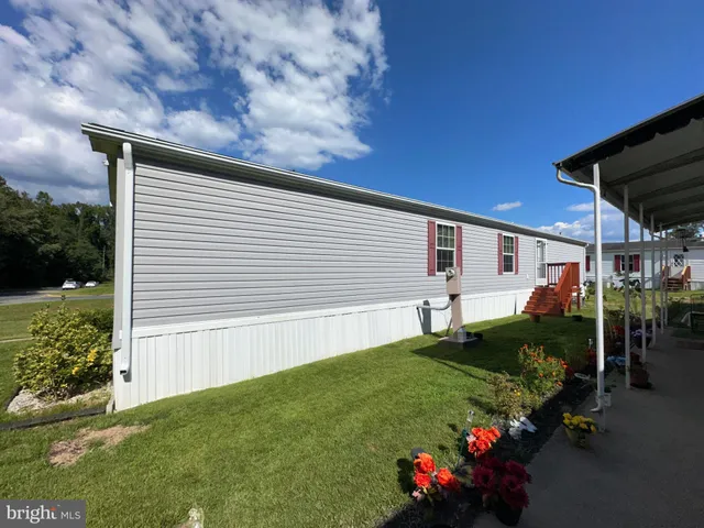 a view of a house with backyard and a trees