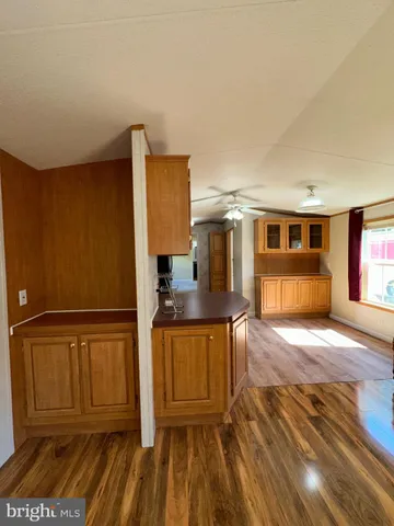 a large kitchen with cabinets wooden floor and stainless steel appliances